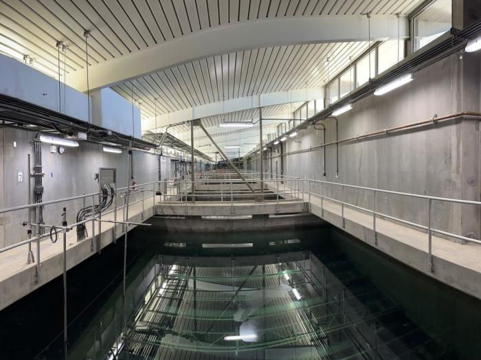 A pool of water surrounded by walkways inside a building. 