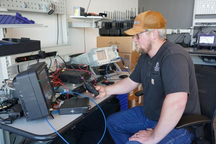 Man works at a desk full of radio and computer equipment