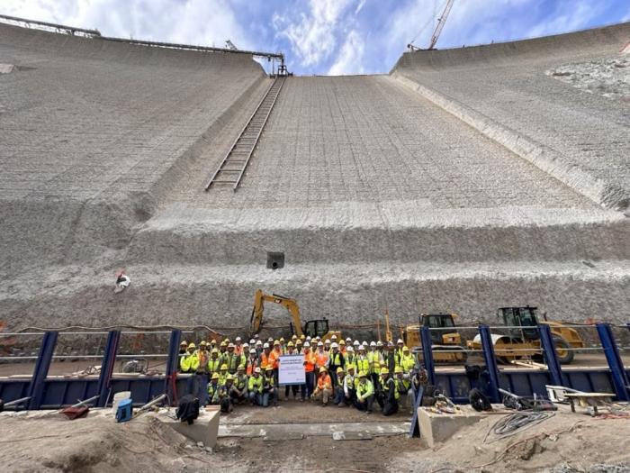 Large group of workers stand at the base of Gross Dam