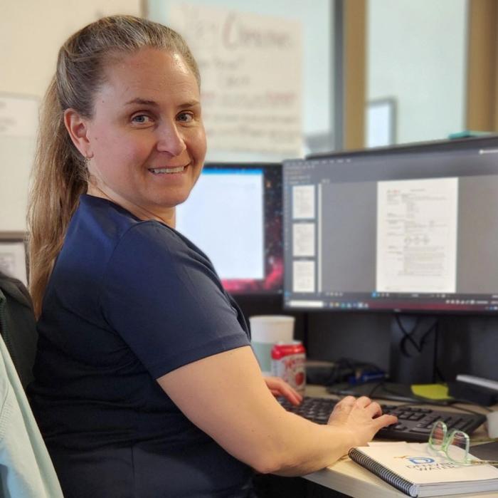 Woman sits at a computer desk