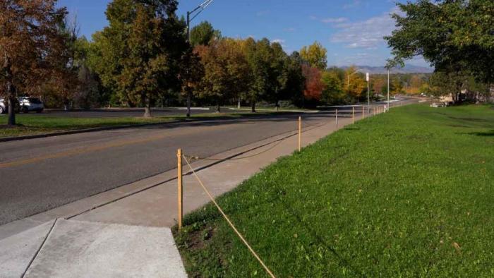 A sidewalk borders a green lawn