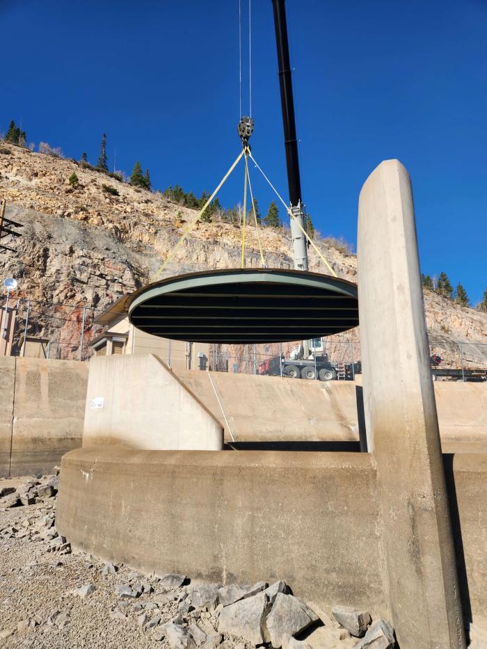 Concrete plug cap being lowered by crane into spillway