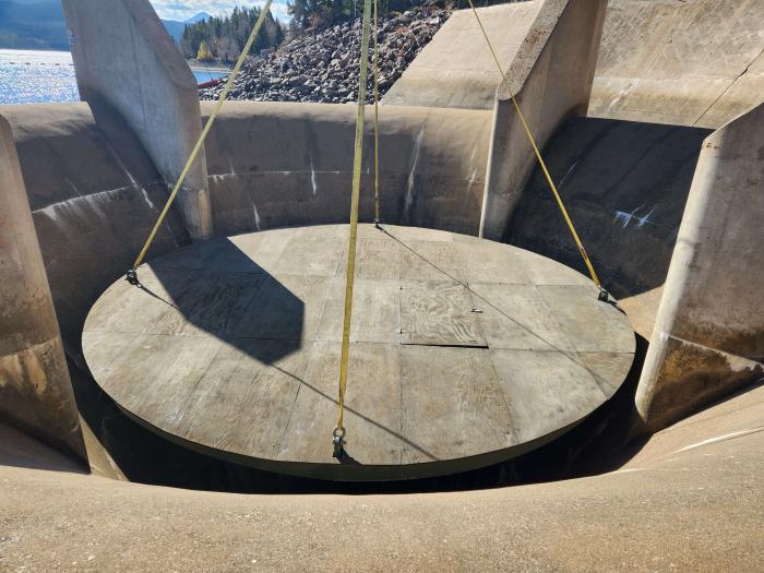 Round concrete plug lowered into spillway in reservoir