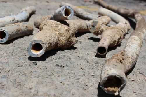 small sections of lead pipes lay on the pavement.