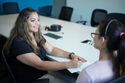 A Talent recruiter meets with a potential candidate in a conference room