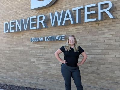 Woman stands in front of Denver Water's logo