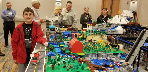 Silas Malers stands beside his giant Lego creation that displays the journey of water